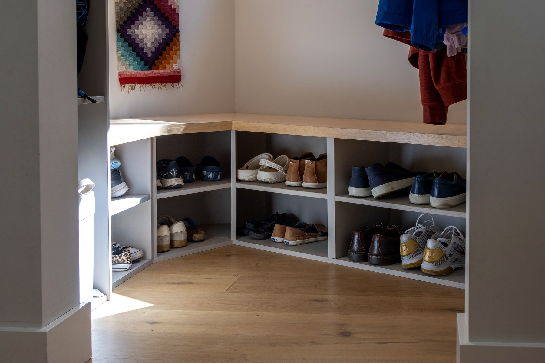 Corner mudroom bench with built-in shoe cubbies
