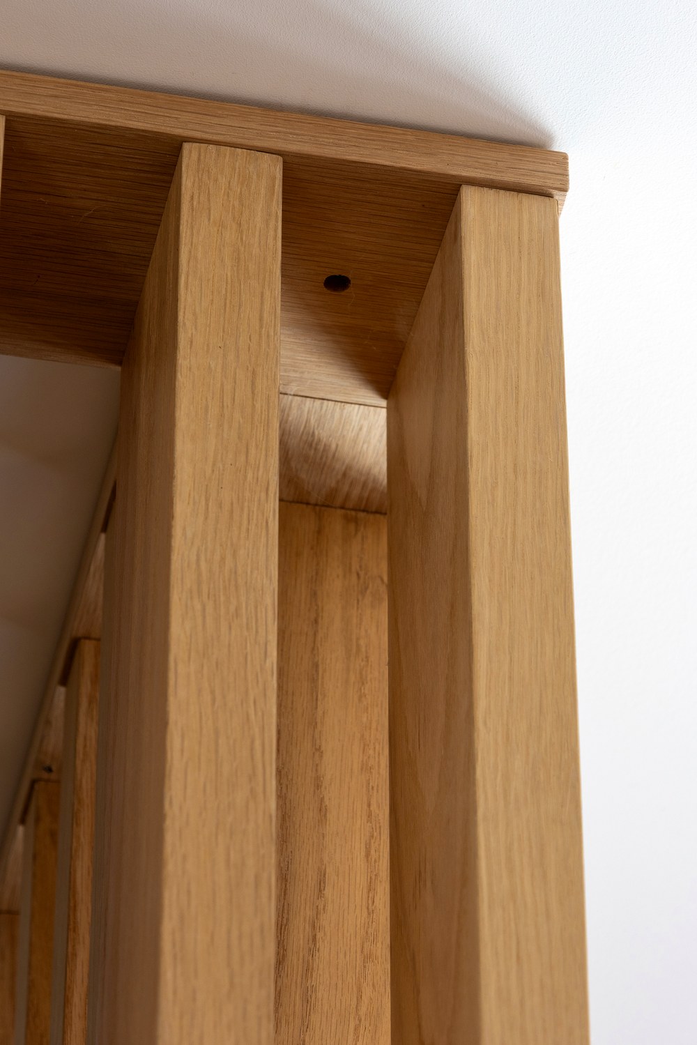 Close-up of the slat wall's oak grain and corner joinery